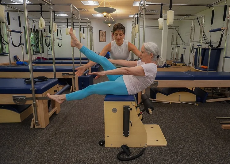 Penelope guiding a client through a reformer session