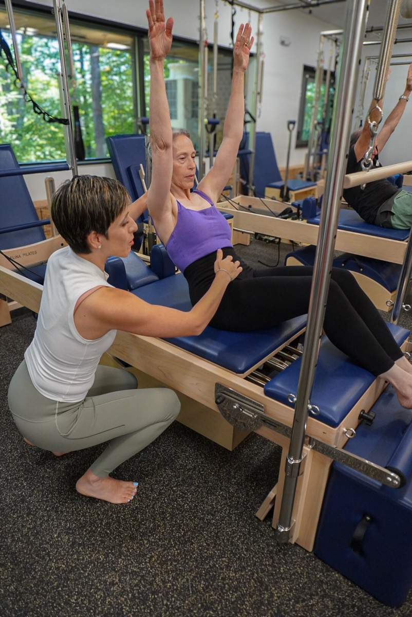 Penélope guiding a client through an exercise on the reformer
